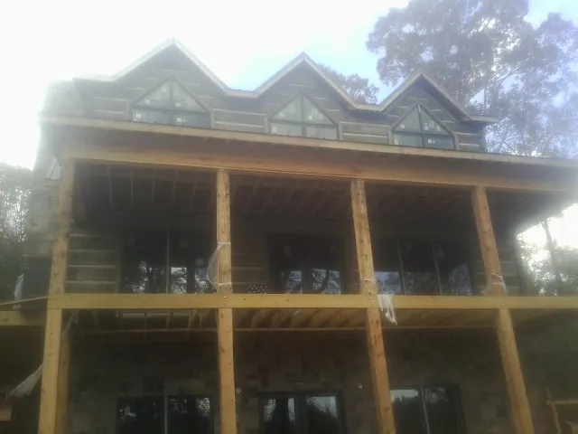 Dormers and porch framing on a large log home under construction — Roof Coating work by our crew in Sylacauga