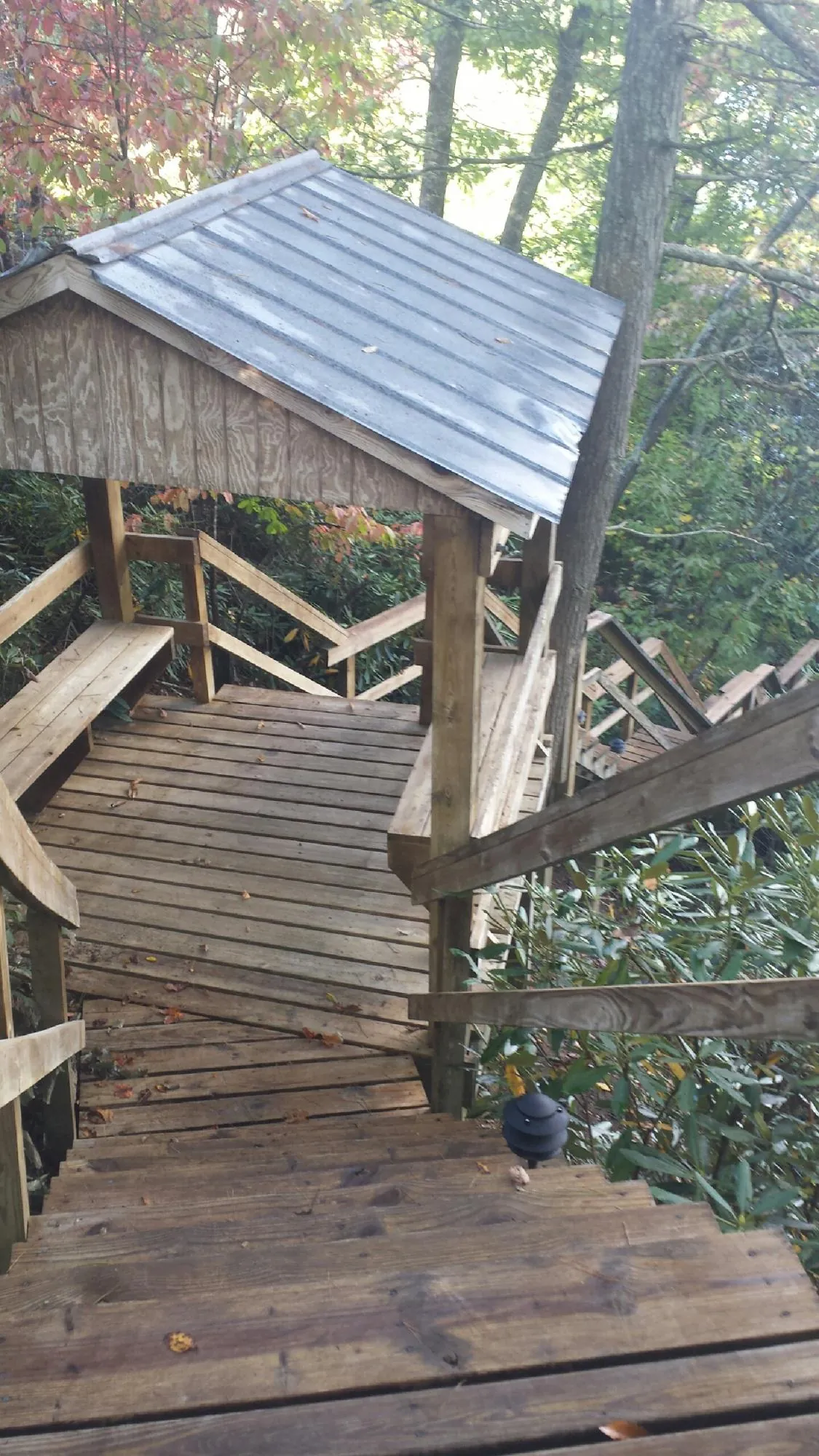 Metal roofed shelter over wooden steps on a wooded walkway — Skylight Repair & Installation work by our crew in Sylacauga