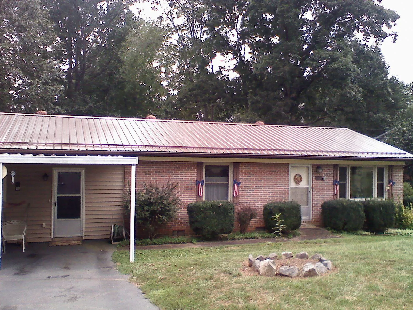Bronze metal roof and carport on a brick ranch home — Roof Repair work by our crew in Sylacauga